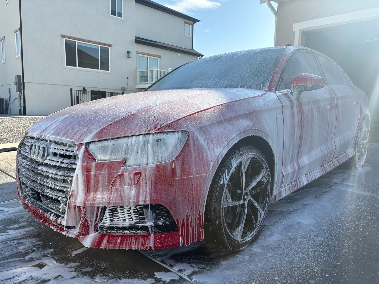 Red Audi covered in foam during an exterior detail